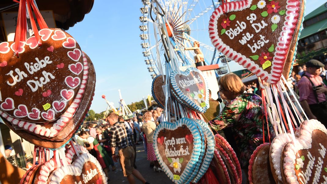 Wiesnherzen und das Riesenrad sind am 25.09.2016 in München (Bayern) auf dem Oktoberfest bei Sonnenschein zu sehen.  