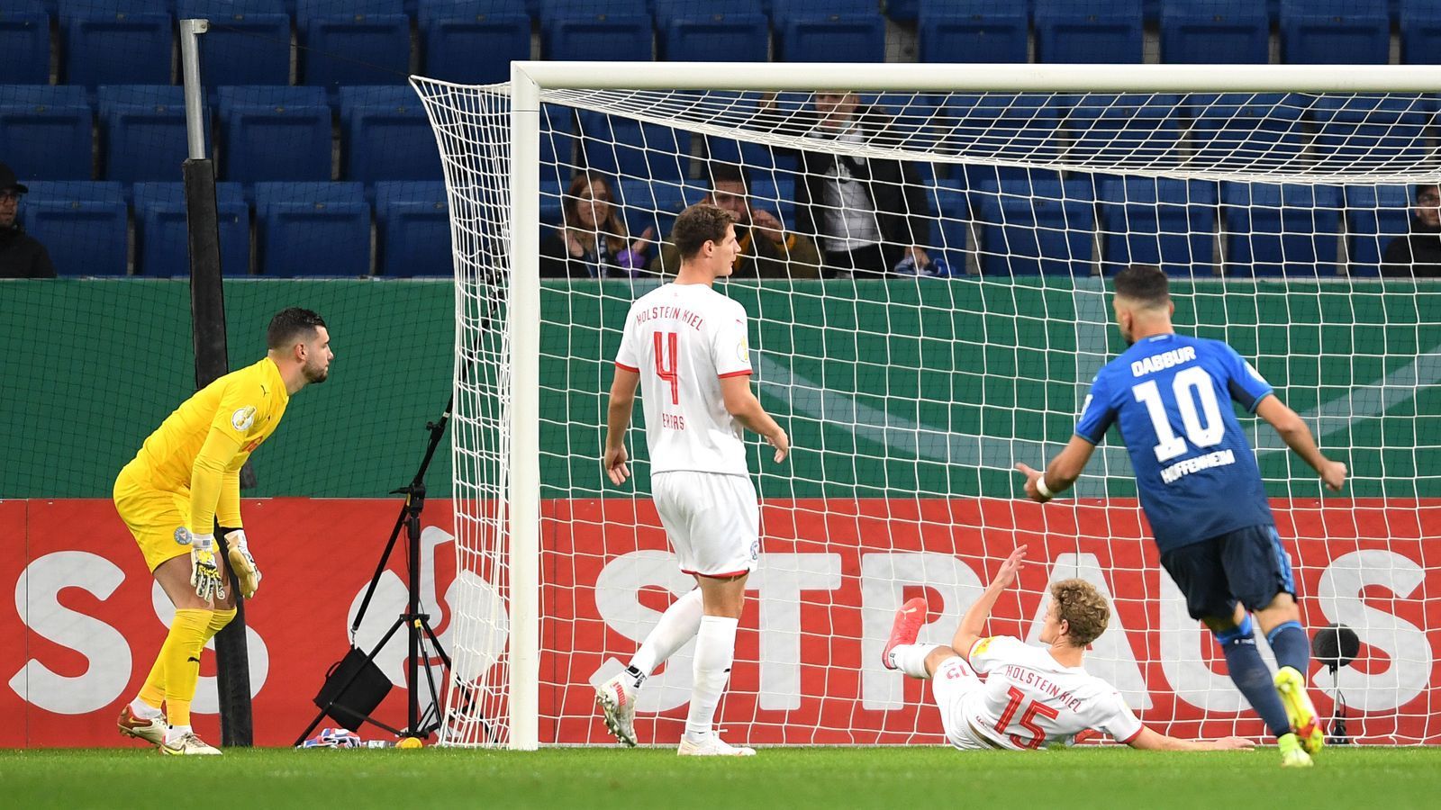 
                <strong>TSG Hoffenheim - Holstein Kiel</strong><br>
                So vorhersehbar der Ausgang der Partie zwischen Bundesligist TSG Hoffenheim und Holstein Kiel sein mochte, so kurios kam es zu den Toren. Bei den ersten beiden Hoffenheimer Treffern legten sich die "Störche" selbst ein Ei ins Nest: Erst traf Johannes van den Bergh (Foto) ins eigene Tor, dann Hauke Wahl. Die Kieler erzielten zwar noch vor der Pause den Anschluss, mussten Hoffenheim aber in der zweiten Hälfte ziehen lassen. Stiller, Dabbur und Bruun Larsen tüteten schließlich den ungefährdeten 5:1-Erfolg für das Team Sebastian Hoeneß ein. 
              