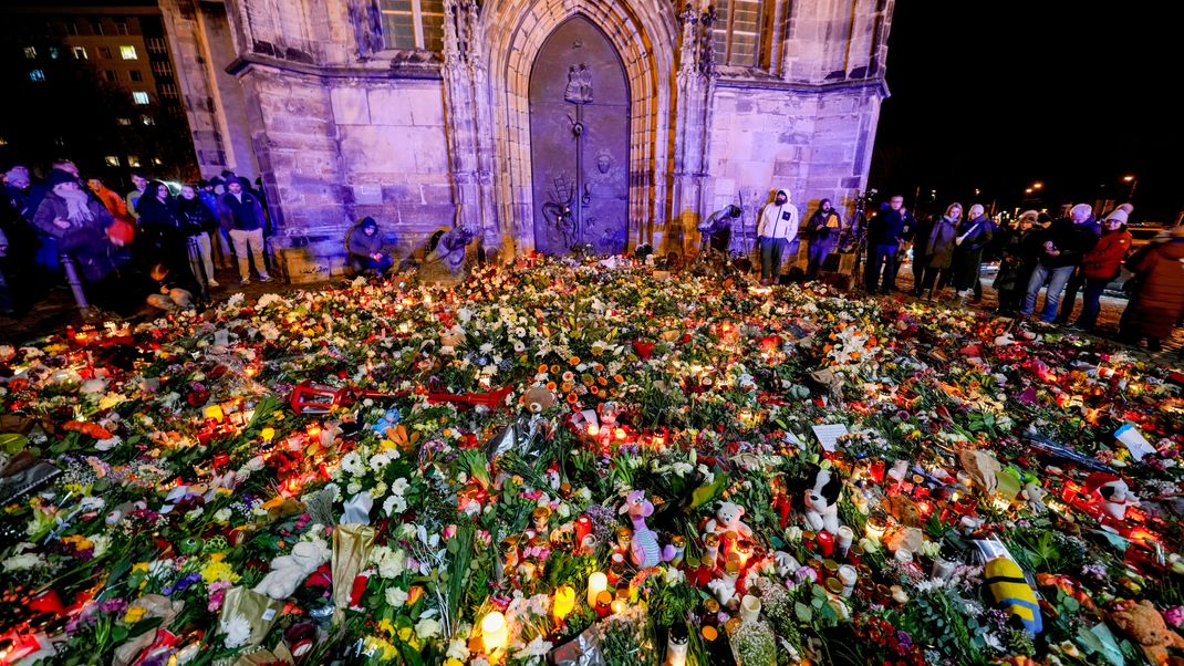 Blumen und Kerzen schmücken den Eingang der Johanniskirche in Magdeburg zum Gedenken an die Opfer des Weihnachtsmarkt-Anschlags.