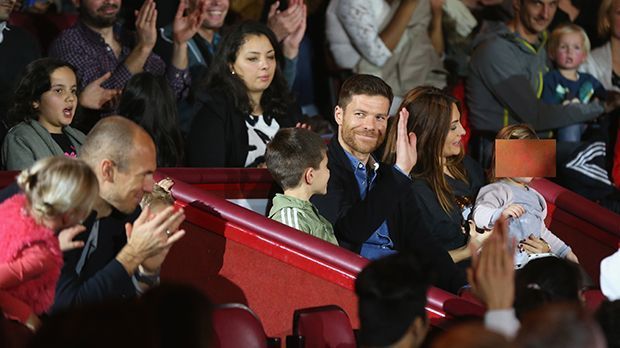 
                <strong>Xabi Alonso mischt sich ins Publikum</strong><br>
                Am Tag zuvor hat Xabi Alonso die Bayern mit einem hammerharten Volleyschuss ins Viertelfinale des DFB-Pokals geschossen. Jetzt winkt der Spanier ganz bescheiden ins Publikum. Arjen Robben und die Zuschauer spenden Applaus.
              