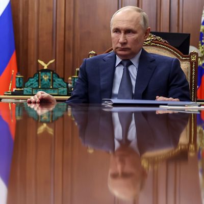 Russlands Machthaber Putin hört am Tisch sitzend einem Meeting zu.