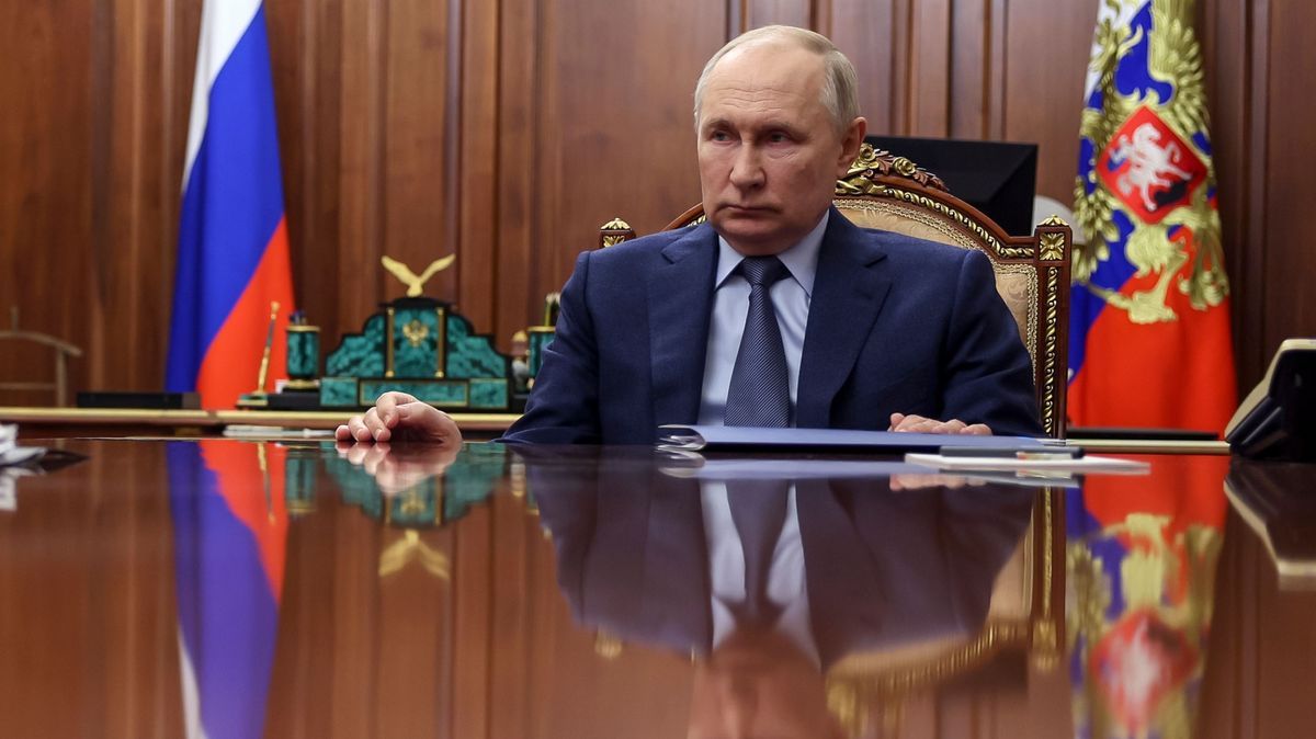 Russlands Machthaber Putin hört am Tisch sitzend einem Meeting zu.
