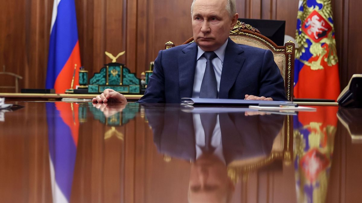 Russlands Machthaber Putin hört am Tisch sitzend einem Meeting zu.