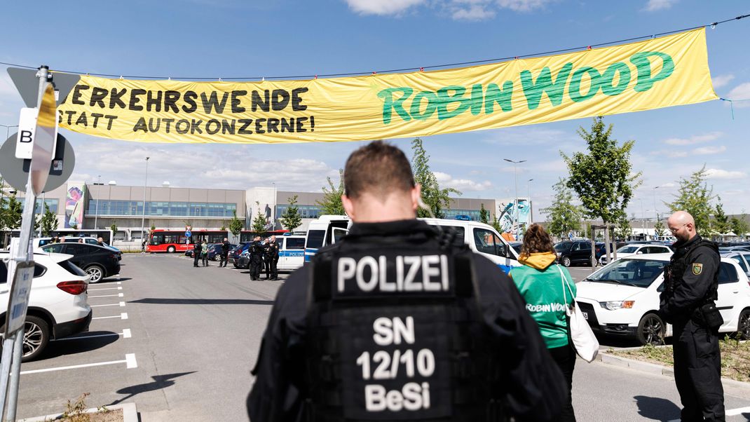  Polizisten sichern eine Aktion von Aktivisten der Naturschutzorganisation Robin Wood über einen Parkplatz vor dem Tesla-Betriebsgelände. 