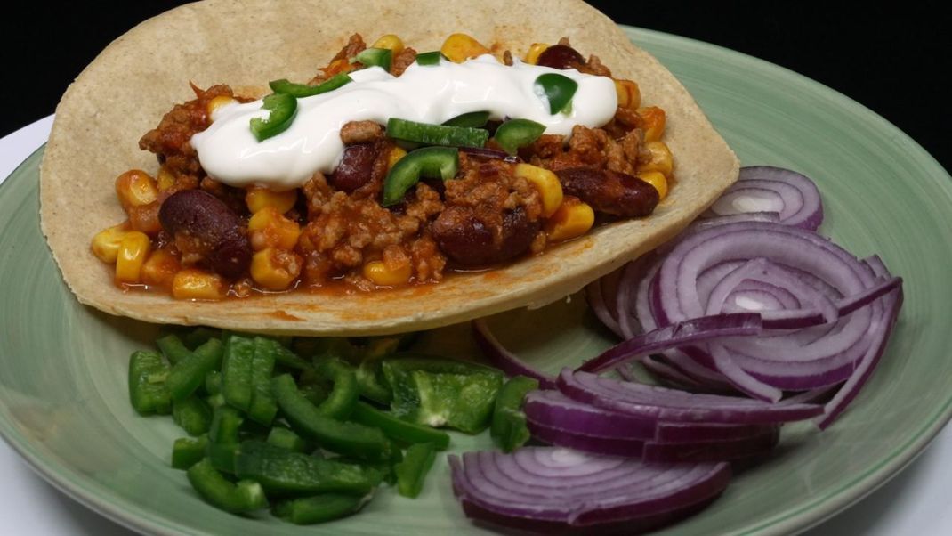 Tacos mit Chili con Carne kannst du blitzschnell zubereiten. Wer etwas Feuriges auf dem Teller haben will, ist mit diesem Rezept auf dem besten Weg.