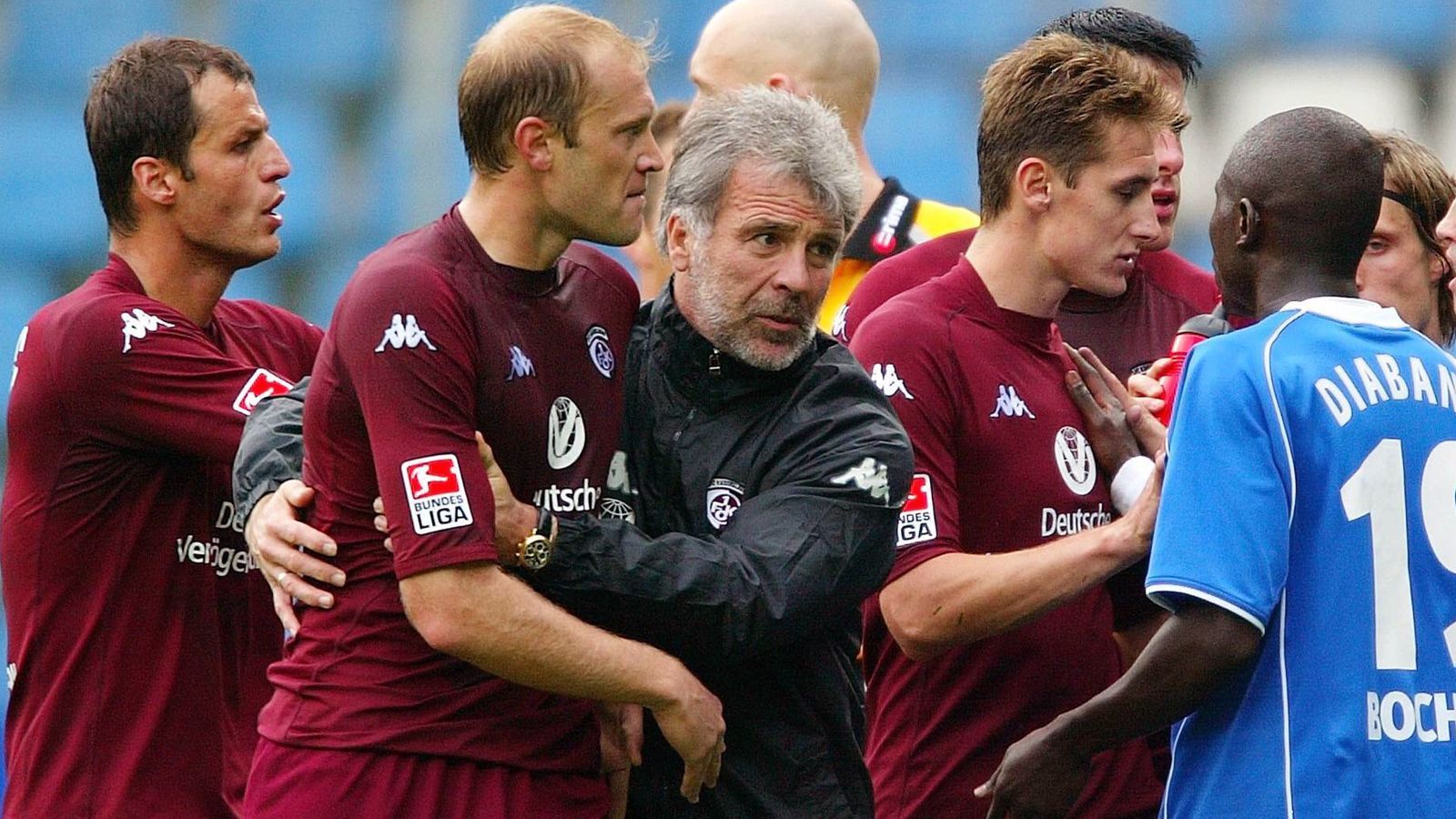 
                <strong>1. FC Kaiserslautern (2004)</strong><br>
                Nichtsahnend nominiert Trainer Eric Gerets (Mi.) im Pokalspiel des VfL Wolfsburg bei den Amateuren des 1. FC Köln Marian Christow (2.v.l.) für die Startformation. Doch der Bulgare ist wegen einer Roten Karte aus der vorvergangenen Saison im Trikot des 1. FC Kaiserslautern nicht spielberechtigt
              