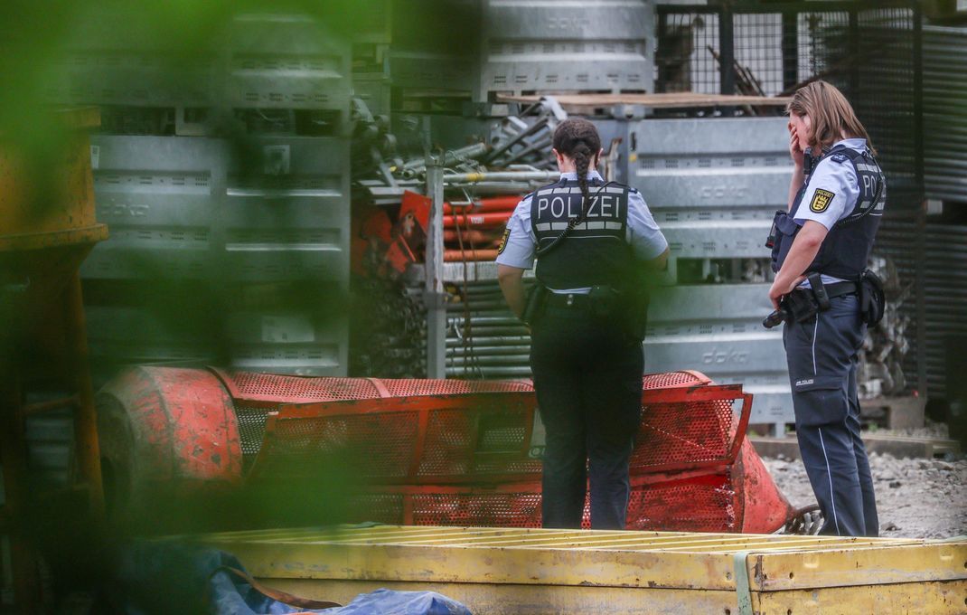Polizistinnen stehen auf der Hochbrücken-Baustelle neben einer Gondel. Beim Absturz einer Brückenbaugondel auf einer der größten Baustellen Baden-Württembergs sind drei Arbeiter gestorben.