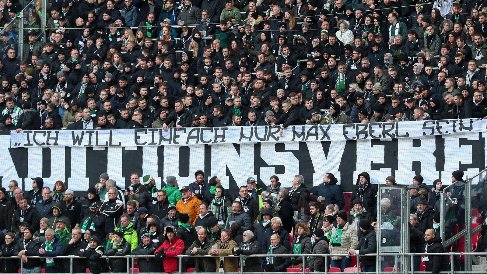 
                <strong>"Ich will einfach nur Max Eberl sein"</strong><br>
                Das Spruchband ging danach auch noch weiter über die gesamte Gästekurve, darauf stand noch: "Ich will einfach nur Max Eberl sein." Dies war einer der Sätze, die von seiner aufsehenerregenden Pressekonferenz zum Abschied aus Gladbach hängen blieben.
              