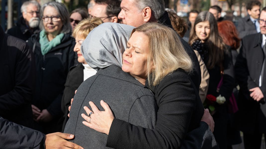 19.02.2024, Hessen, Hanau: Bundesinnenministerin Nancy Faeser (r., SPD) umarmt auf einer Trauerfeier für die Opfer des rassistischen Anschlags von Hanau eine Frau. Ein Rassist hatte am 19. Februar 2020 neun Menschen erschossen, bevor er auch seine Mutter und sich selbst tötete. Foto: Boris Roessler/dpa +++ dpa-Bildfunk +++