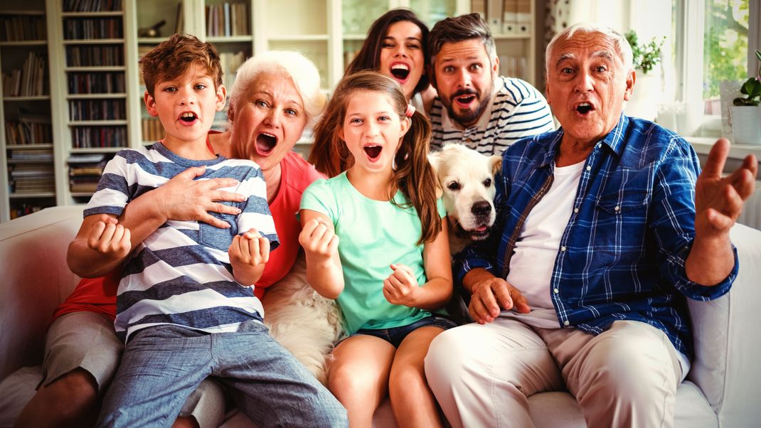 Happy family watching television in living room