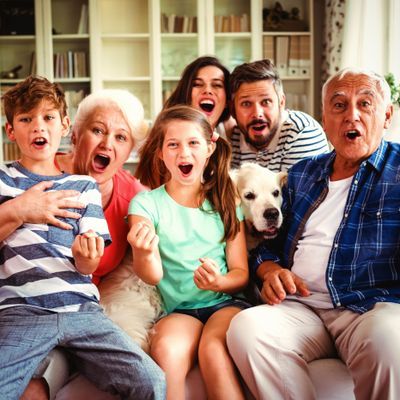 Happy family watching television in living room