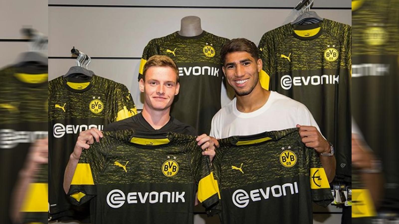
                <strong>Borussia Dortmund (Auswärtstrikot)</strong><br>
                Die BVB-Youngsters Sergio Gomez und Achraf Hakimi präsentieren den neuen Auswärts-Look des BVB. Das Trikot ist überwiegend in Schwarz gehalten, der Brustbereich ist mit gelben Farbtupfern gesprenkelt.
              