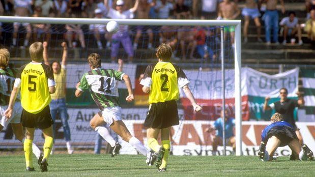 <strong>Borussia Dortmund gegen SpVgg Greuther Fürth (1990/91)</strong><br>
                Im selben Jahr erwischt es auch Borussia Dortmund bereits in der 1. Runde. Bei der SpVgg Fürth verlieren die Borussen mit 1:3. Zettl (Nr. 11) erzielt für den damaligen Viertligisten das erste und das dritte Tor.
