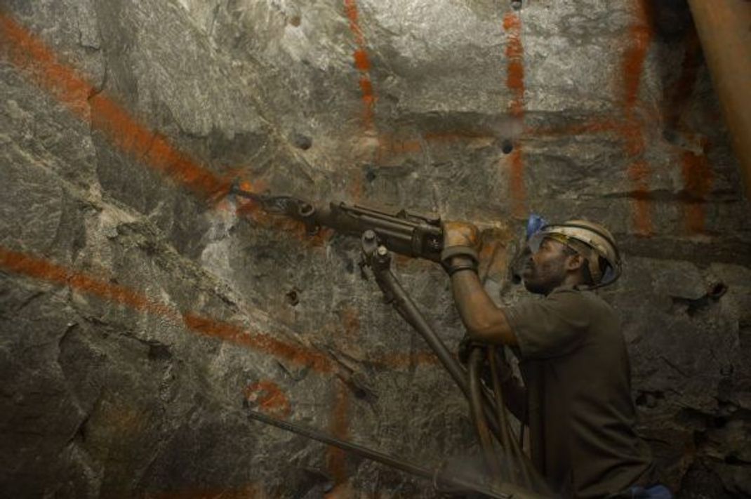 Ein Arbeiter bohrt in einer südafrikanischen Mine nach Gold.