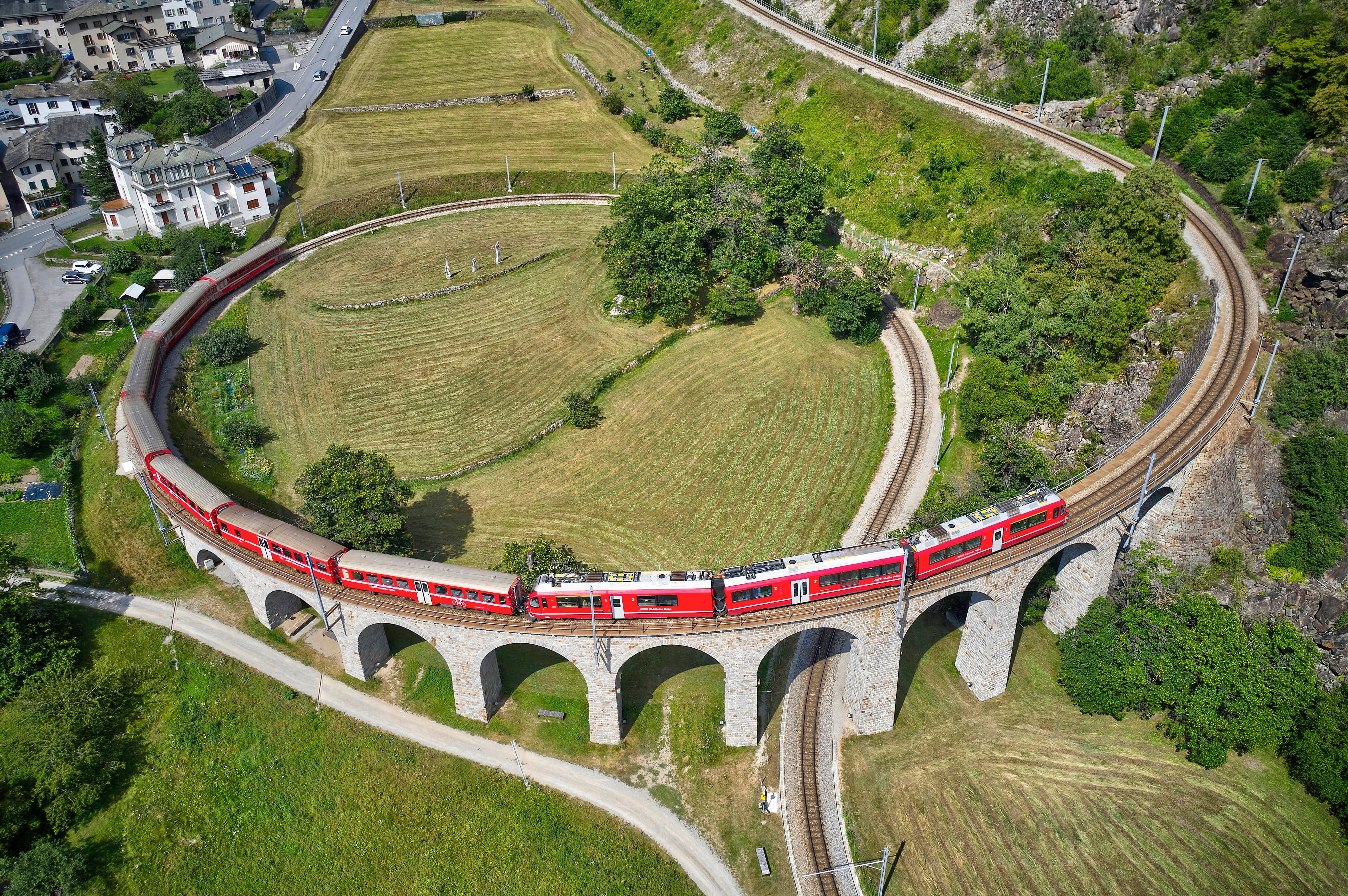 Die Strecke des Schweizer Bernina Express gehört zum Weltkulturerbe. Hier fährt der Zug auf dem Weg nach Italien über das Kreisviadukt von Brusio.