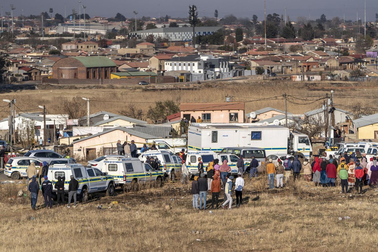 Das Soweto (South Western Townships) ist eine (frühere) Township von Johannesburg. Auf dem Foto siehst du, wie sich Menschen im Juli 2022 nach einer nächtlichen Schießerei in einer Bar versammelt haben.