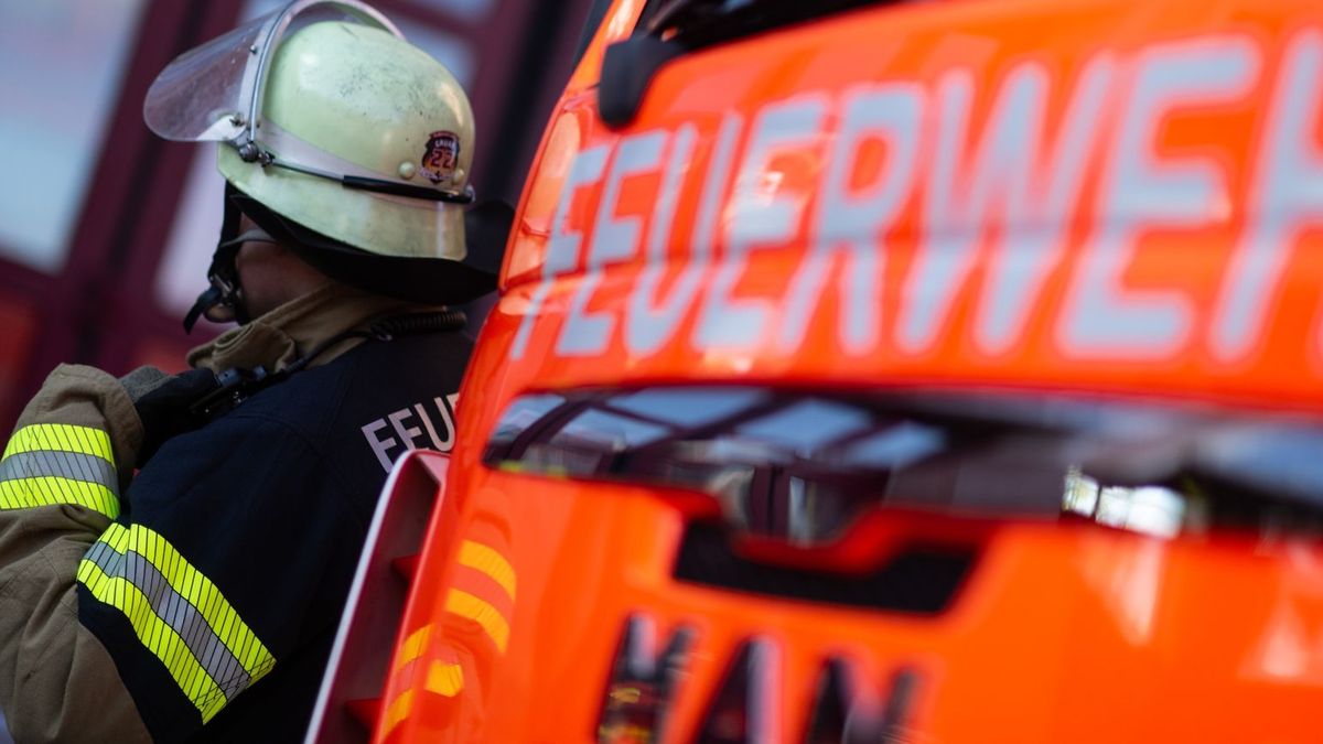 Feuerwehrmann steht neben einem Feuerwehrauto (Symbolbild)