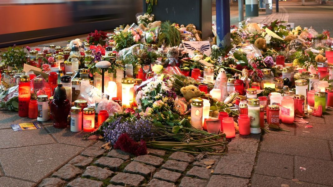 Magdeburg: Blumen und Kerzen stehen im Gedenken an die Anschlagsopfer an einer Straßenbahnhaltestelle.