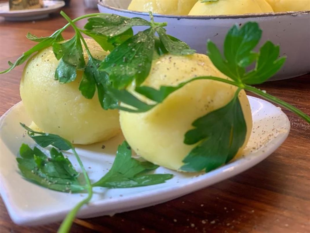 Kartoffelklöße sind einfacher zuzubereiten als du denkst. Durch das Mehl haben die Fränkischen Klöße eine weiße Farbe, im Gegensatz zu beispielsweise den Thüringer Klößen. Als Deko kannst du ein paar Blätter frische Petersilie auf die Klöße legen. 