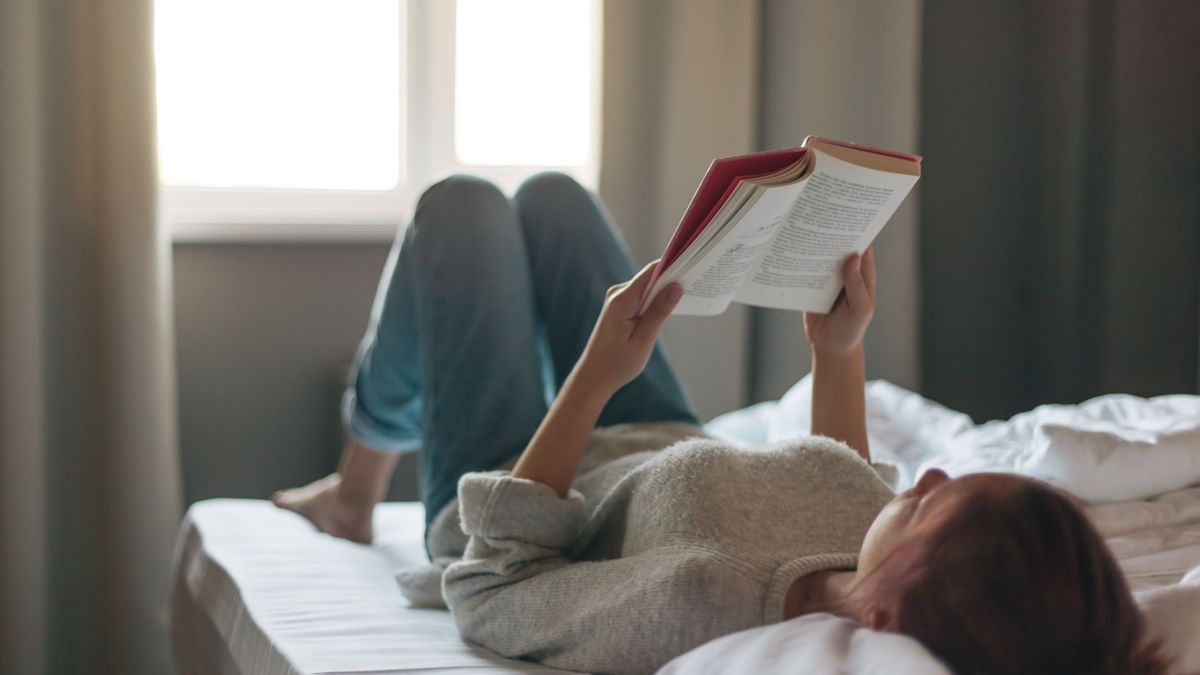 Girl reading a book in bedroom