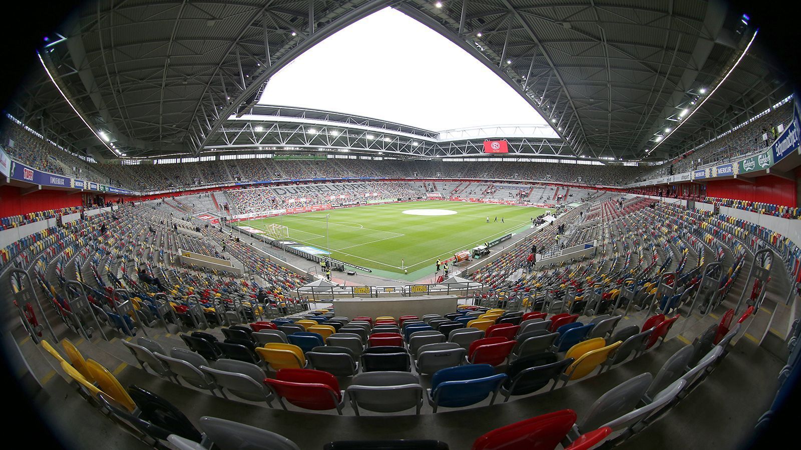 
                <strong>Fortuna Düsseldorf: Farbenspiel und schließbares Dach</strong><br>
                Selbst wenn die Merkur-Spiel-Arena auf dem Düsseldorfer Messegelände nicht so gut besucht ist, wirkt es, als wäre kaum ein Platz leer. Grund sind die bunten Stadionsitze in der Arena. Kaum ein Stuhl hat die gleiche Farbe wie der Nachbarsitz. Der optische Effekt vermittelt im Fernseher das Bild eines vollen Stadions. Das Dach der Multifunktionsarena ist komplett verschließbar.
              