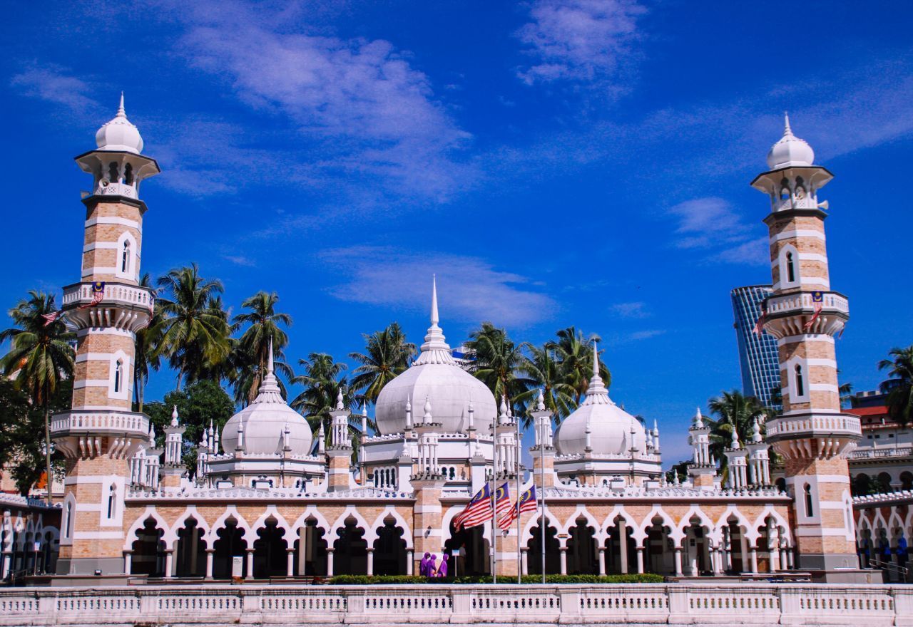 Die 1909 erbaute Masjid Jamek im historischen Zentrum ist eine der ältesten Moscheen Kuala Lumpurs - und auch eine der schönsten. Der britische Architekt Arthur Benison Hubback gestaltete den Backstein-Komplex mit seinen Minaretten, Kuppeln und Säulengängen im nordindischen Stil. Im Gebetsraum finden 15.000 Gläubige Platz, der Zugang ist Muslim:innen vorbehalten. Wer an einer Führung durch die Moschee teilnehmen möchte, siche