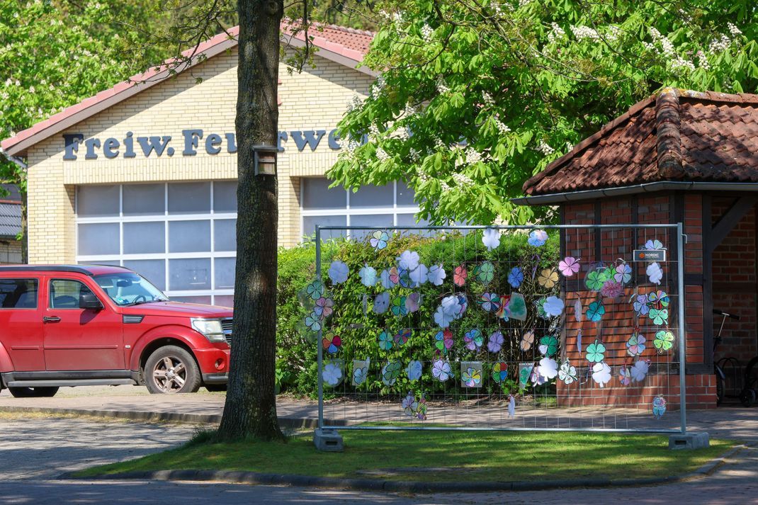 Gebastelte Kleeblätter mit Wünschen für den vermissten Jungen Arian hängen vor dem Bürgerhaus an einem Zaun. Im Hintergrund ist die geschlossene Feuerwehrwache zu sehen, die während der intensiven Suche nach dem sechsjährigen als Einsatzzentrale eingerichtet war. 