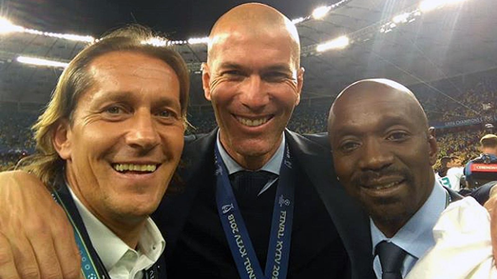 
                <strong>Michel Salgado, Zinedine Zidane und Claude Makelele (v.l.n.r.)</strong><br>
                Ein Bild, drei Real-Ikonen! Der siegreiche Trainer Zinedine Zidane (Mi.) war nach dem Schlusspfiff in Selfie-Laune. Zusammen mit früheren Weggefährten wie Michel Salgado (li.) und Claude Makelele (re.) posierte der Franzose für einen Erinnerungs-Schnappschuss. Im Jahr 2002 gewannen die drei den Henkelpott noch als Aktive. Damals sorgte "Zizou" durch ein Traumtor gegen Bayer Leverkusen für die Entscheidung zugunsten Real Madrids.
              