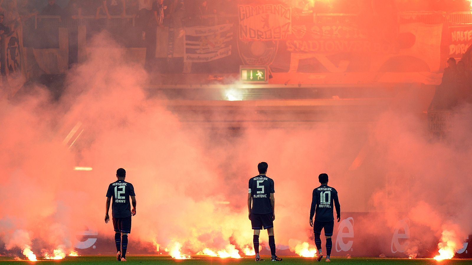 
                <strong>Fortuna Düsseldorf - Hertha BSC</strong><br>
                Schiedsrichter Wolfgang Stark musste das Spiel nach dem 2:1 für Düsseldorf unterbrechen, weil Hertha-Fans Knallkörper zündeten und bengalische Feuer auf den Rasen warfen. Die Düsseldorfer Anhänger antworteten ihrerseits mit dem Werfen von Pyros, die vereinzelt auf dem Feld landeten. Nach dem 2:2-Ausgleich durch Berlins Stürmer Raffael in der 85. Minute wiederholte sich das Schauspiel. Die Partie musste zum zweiten Mal unterbrochen werden. Der Stadionsprecher übermittelte eine finale Warnung. Polizisten positionierten sich vor dem Gästeblock. Die Spannung war zum Greifen.
              