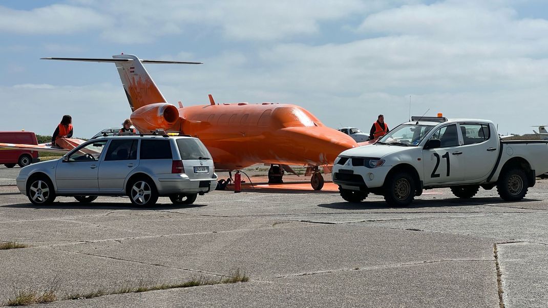 Ein von Klimaschutz-Aktivisten der Initiative Letzte Generation mit oranger Farbe besprühter Jet steht auf einem Rollfeld. 