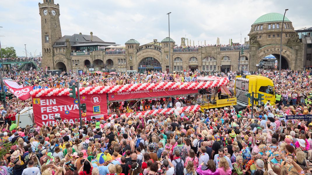 Teilnehmer:innen des Schlagermoves ziehen in einer Schlagerkarawane durch den Stadtteil St. Pauli. 