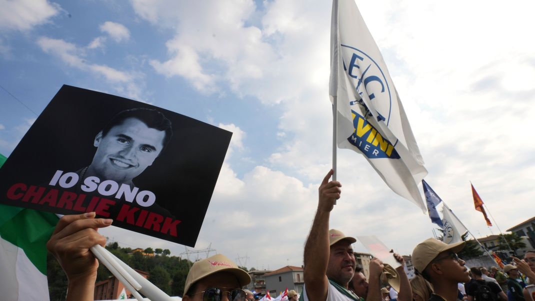 Eine Frau hält bei der jährlichen Versammlung der Lega-Partei am Sonntag, 21. September 2025, in Pontida im Norden Italiens ein Foto von Charlie Kirk mit der Aufschrift "Ich bin Charlie Kirk" hoch.