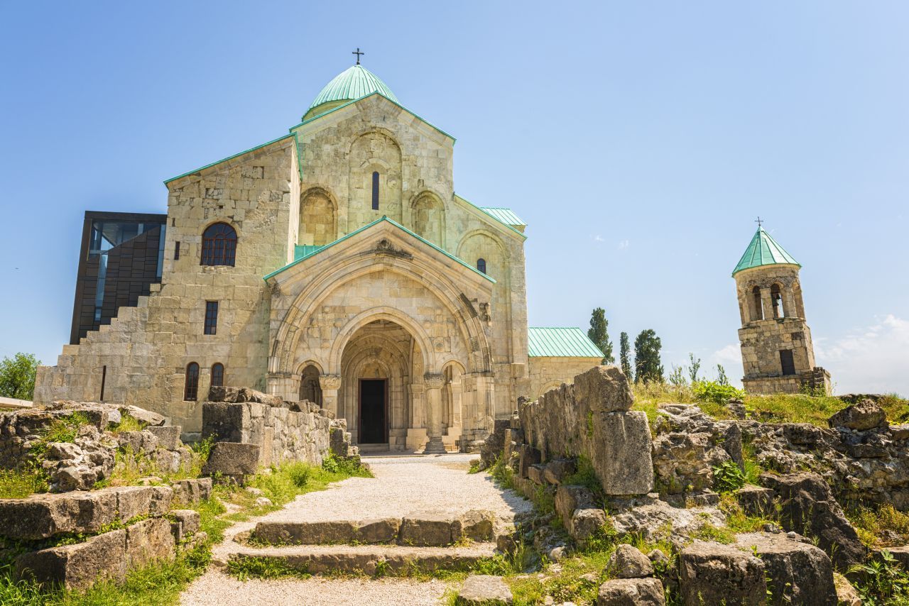 In Kutaissi und drumherum wird‘s mittelalterlich. Die Bagrati-Kathedrale auf einem Hügel über dem Fluss Rioni stammt aus dem 11. Jahrhundert. Ähnlich alt und ähnlich beeindruckend ist das Kloster Gelati. Aber es gibt noch einen weiteren Grund, die Stadt zu besuchen. Der lokale Markt ist einer der größten in Westgeorgien. Angeboten werden feine Produkte aus der Region. Zu den Spezialitäten zählt Tschurtschchela: eine mit Traub