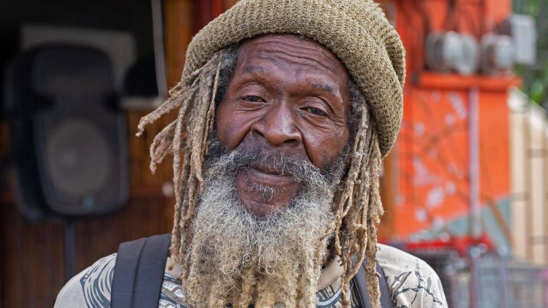 Ein typischer Rastafari trägt Dreadlocks, einen Bart und eine Mütze.