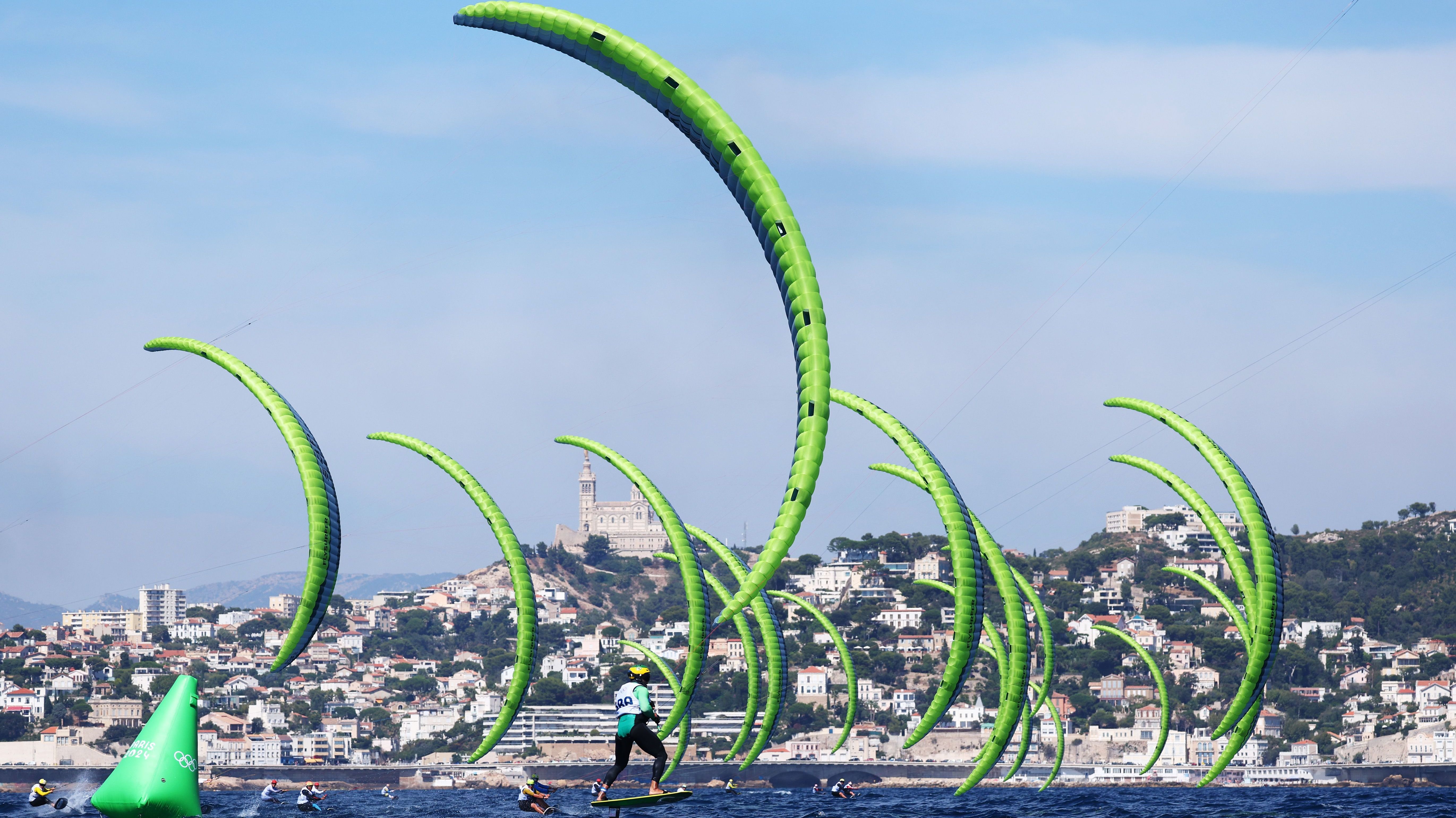 <strong>Olympia 2024: Die besten Bilder des neunten Tages</strong><br>Kitesurfen ist auch Teil des olympischen Programms. Wobei man bei diesem Bild auch denken könnte, dass Riesenerbsenschoten einen Angriff starten.