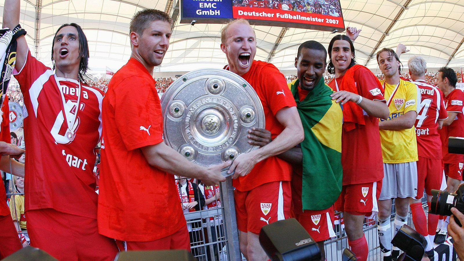 
                <strong>VfB Stuttgart (Saison 2006/07)</strong><br>
                Der VfB Stuttgart sicherte sich zwar erst am 34. Spieltag der Saison 2006/07 durch einen 2:1-Sieg über Energie Cottbus endgültig den Titel, doch den wohl entscheidenden Schritt machten die Schwaben um den späteren Sportvorstand Thomas Hitzlsperger (2.v.l.) bereits eine Woche zuvor. Trotz zweimaligen Rückstandes gewannen die jungen Stuttgarter beim VfL Bochum noch mit 3:2, während Titelkonkurrent Schalke 04 im Revierderby bei Borussia Dortmund patzte (0:2). So übernahm der VfB um Coach Armin Veh am 33. Spieltag die Tabellenführung - und gab sie nicht wieder her. Den entscheidenden Treffer zum VfB-Titel gegen Cottbus erzielte der spätere Weltmeister Sami Khedira (5.v.l.). Stuttgart beendete die Saison mit 70 Punkten, zwei Zähler vor Schalke.
              