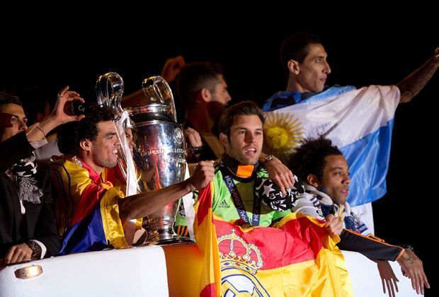 
                <strong>Real: Der Empfang in Madrid</strong><br>
                Alle Mann hoch oben auf dem Bus und in ihren Landesfahnen eingehüllt. So zieht der Siegeszug durch Madrid.
              