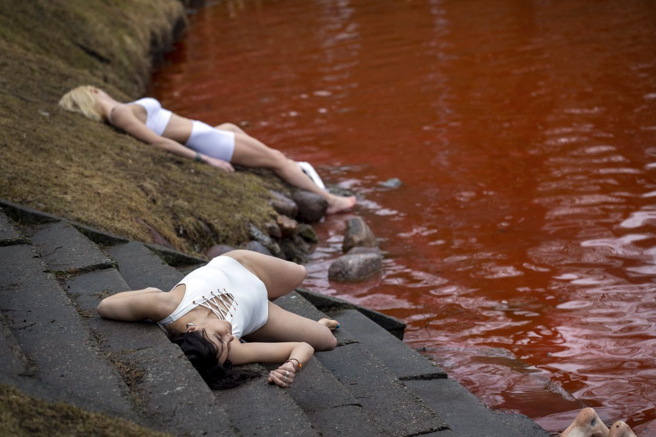 Bei einer Protest-Aktion in Vilnius (Litauen) am Donnerstag, 07. April 2022 liegen Menschen in der Nähe eines rot gefärbten Teiches vor der russischen Botschaft auf dem Boden, um die im Krieg gegen die Ukraine getöteten Menschen zu symbolisieren.