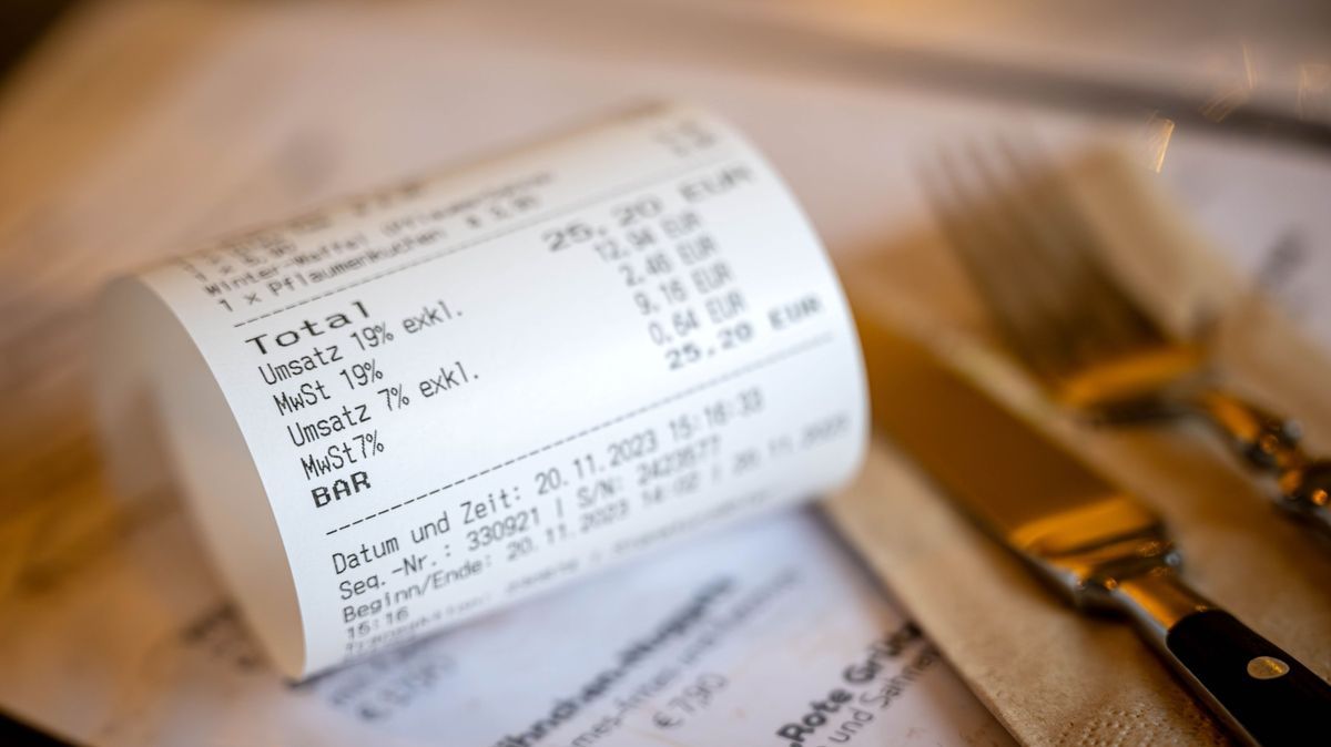 Rechnung mit Umsatzsteuer und Mehrwertsteuer liegt auf der Speisekarte eines Restaurants 435527332