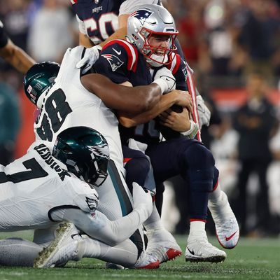 New England Patriots Quarterback Mac Jones (oben r) wird von Philadelphia Eagles Linebacker Haason Reddick (7) und Defensive Tackle Jalen Carter (Ml) zu Fall gebracht.