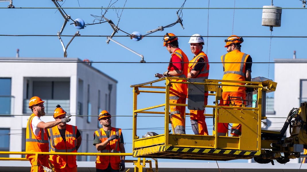 Arbeiter reparieren am Bahnhof Laim eine abgerissene Oberleitung.