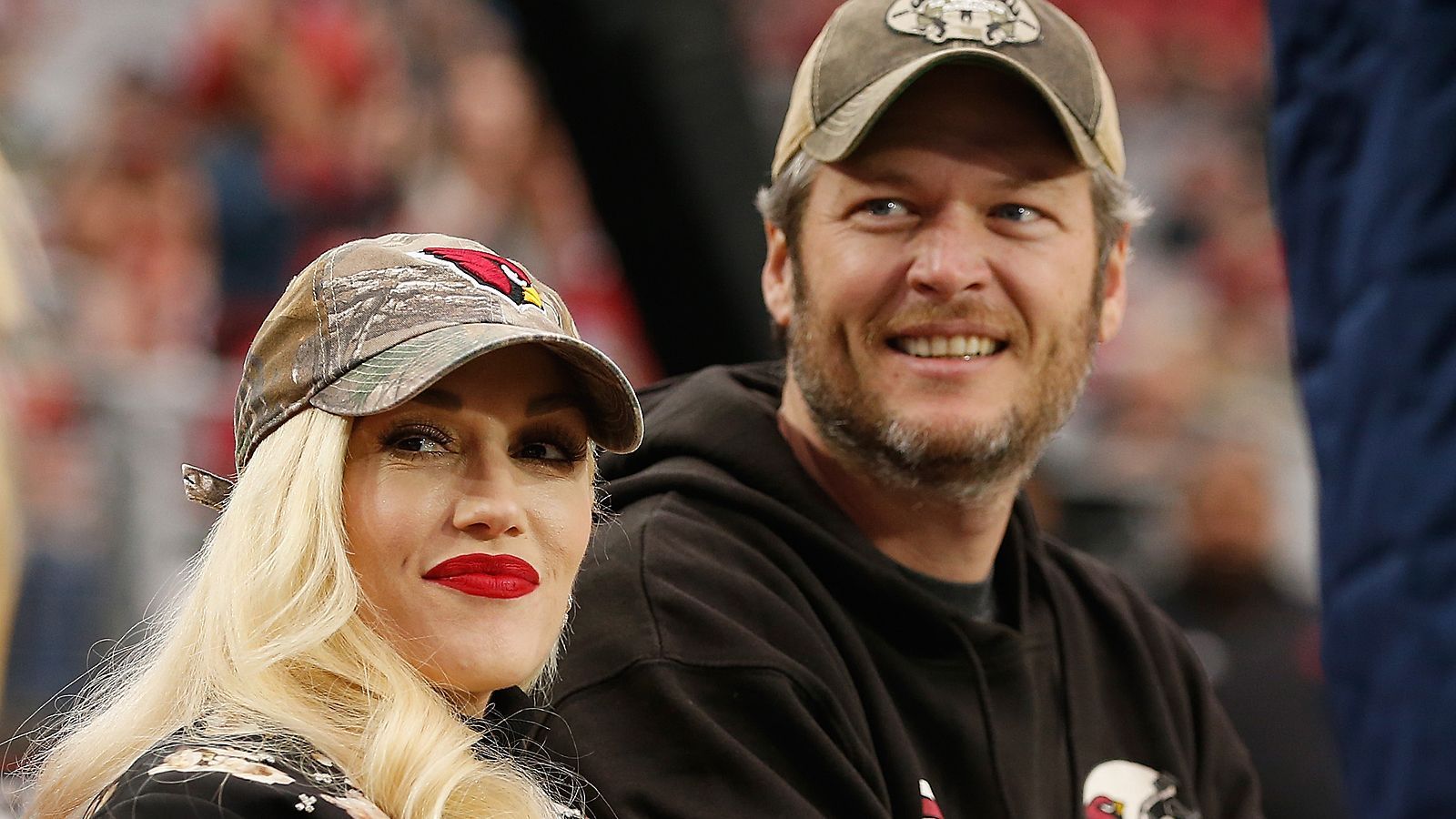 <strong>Gwen Stefani und Blake Shelton (Arizona Cardinals)</strong><br>
                Die Cardinals dürfen sich mit zwei Musik-Megastars schmücken. Grammy-Gewinnerin Gwen Stefani und Country-Legende Blake Shelton besuchen, wann immer es geht, die Spiele der Cards. Meistens im Doppelpack, schließlich sind die beiden seit 2021 verheiratet.
