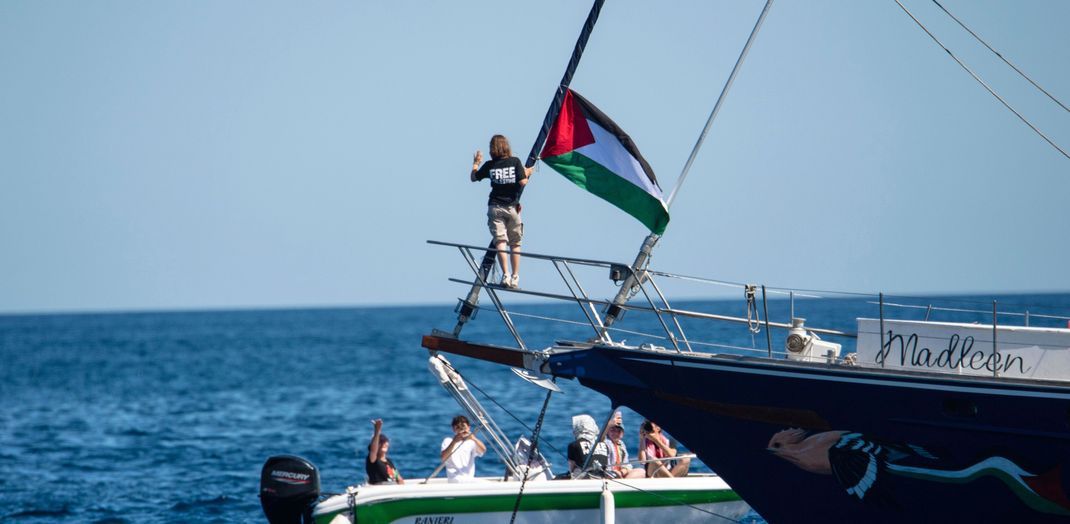 Die Klimaaktivistin Greta Thunberg steht neben einer palästinensischen Flagge, nachdem sie an Bord des Bootes "Madleen" gegangen ist.
