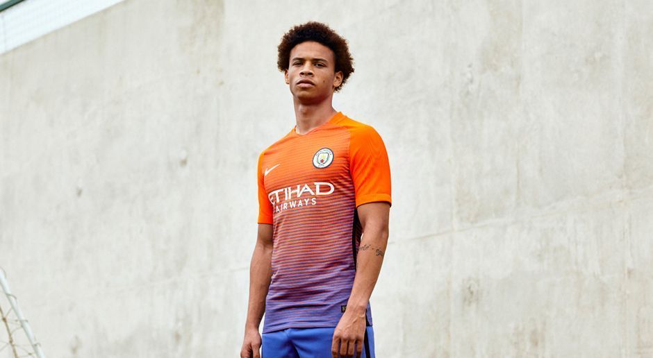 
                <strong>Manchester City Ausweichtrikot</strong><br>
                Leroy Sane hat das neue Ausweichtrikot von Manchester City vorgestellt. Der Neuzugang vom FC Schalke 04 scheint also schon voll bei den "Skyblues" integriert zu sein. Von himmelblau ist dieses Jersey aber weit entfernt: Der farbliche Übergang von dunklem Blau in ein helles Orange erinnert dann doch eher an alte Auswärtstrikots vom SV Werder Bremen.
              