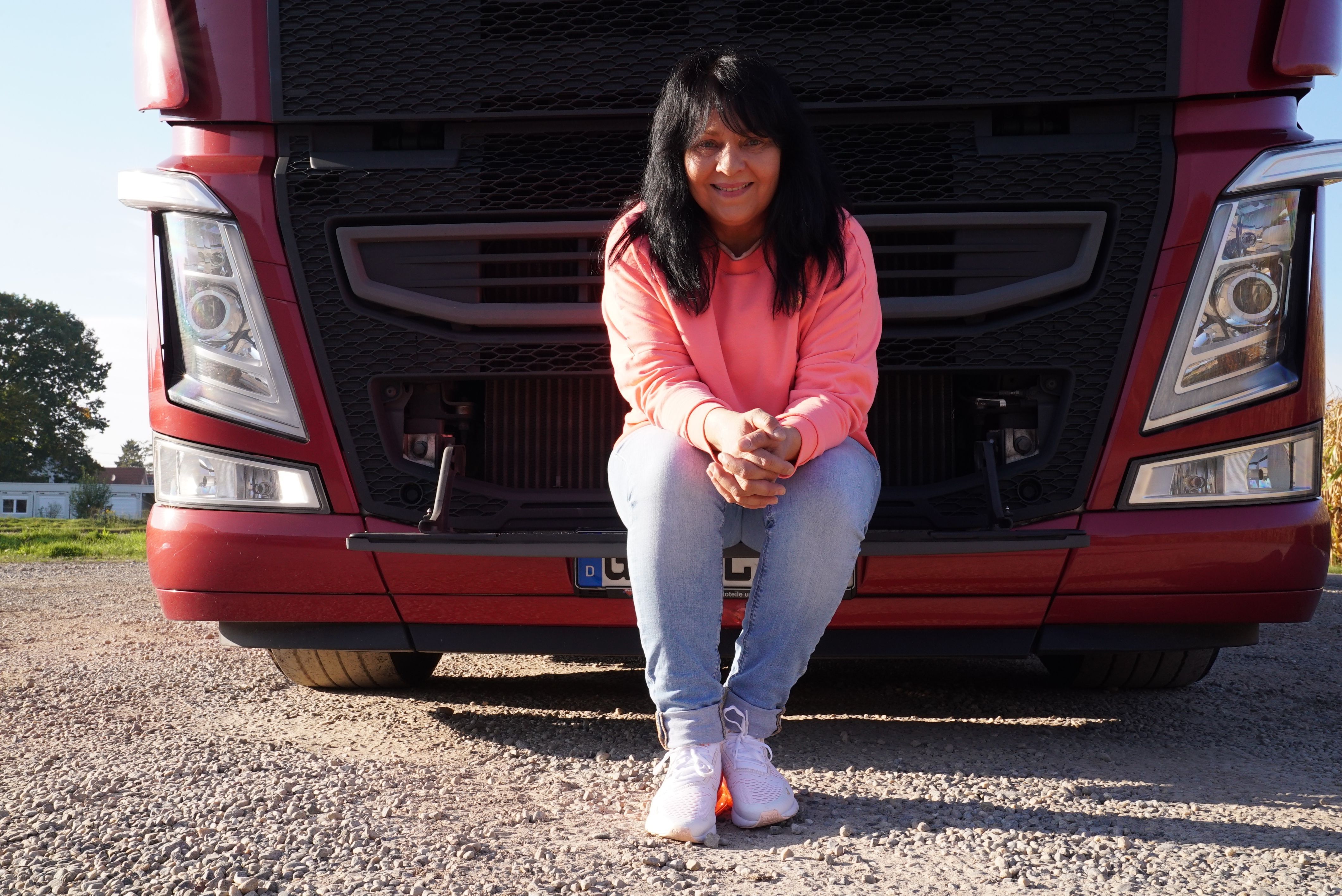 In die Kamera lächelnd präsentiert sich "Trucker Babe" Annette vor ihrem Sattelschlepper mit Auflieger, mit welchem sie im Jahr ungefähr 160.000 km fährt.