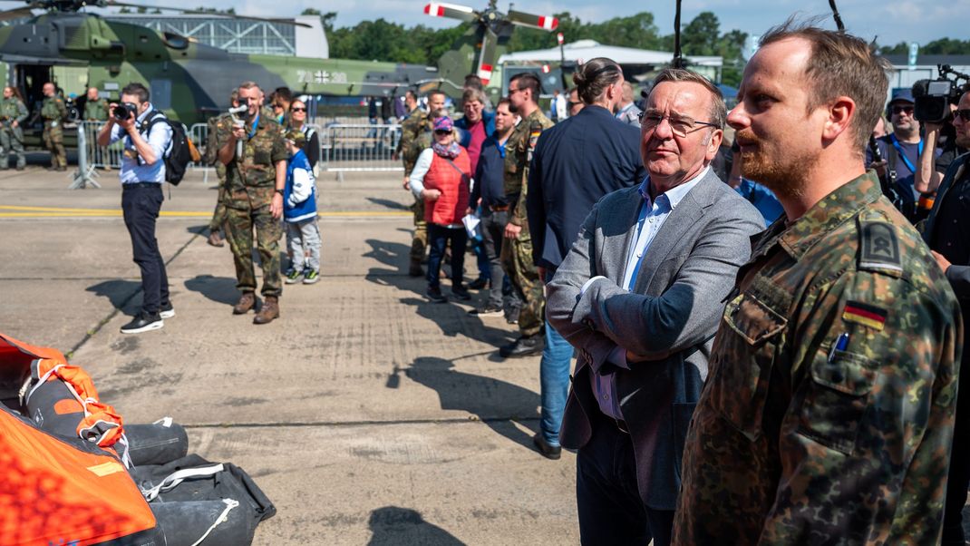 Boris Pistorius (SPD, zweiter von rechts), Bundesminister für Verteidigung, spricht beim Tag der Bundeswehr (8. Juni) mit einem Soldaten.