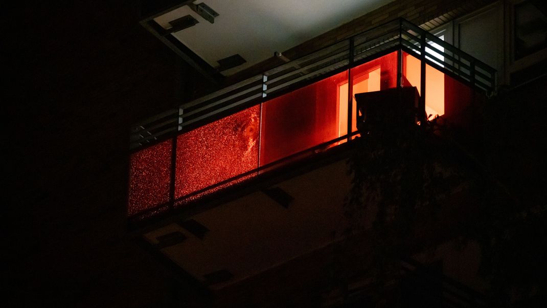 Eine Scheibe mit Einschussloch ist an einem Balkon in Altona zu sehen, nachdem eine Person mit einer Schusswaffe einen Großeinsatz der Polizei ausgelöst hat.