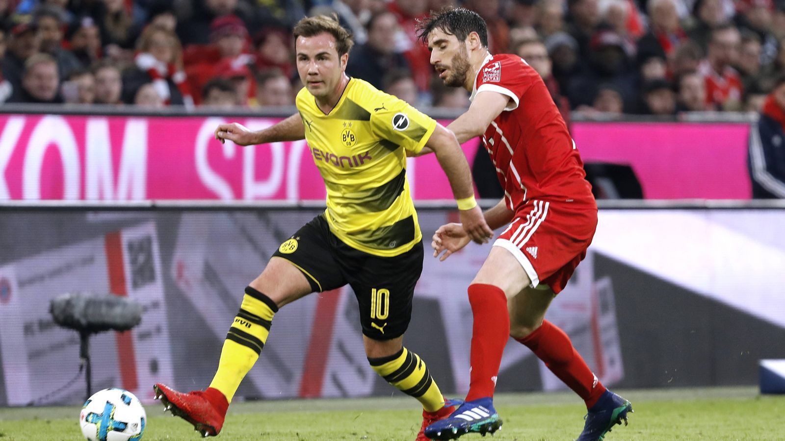 
                <strong>Mario Götze, Weltmeister 2014</strong><br>
                Bundesliga-Spiele/-Tore: 157/35 für Dortmund, 73/22 für die Bayern. Mit 17 Jahren debütiert Götze (im Bild li.) 2009 für den BVB in der Bundesliga. Mit den Dortmundern wird er zweimal Meister und einmal Pokalsieger. Dann wechselt er 2013 für drei Jahre zu den Bayern, mit denen er drei Meisterschaften und zwei Pokalsiege feiert und trotzdem nicht wirklich glücklich wird. 2016 dann wieder zurück nach Dortmund, Pokalsieger 2017.
              