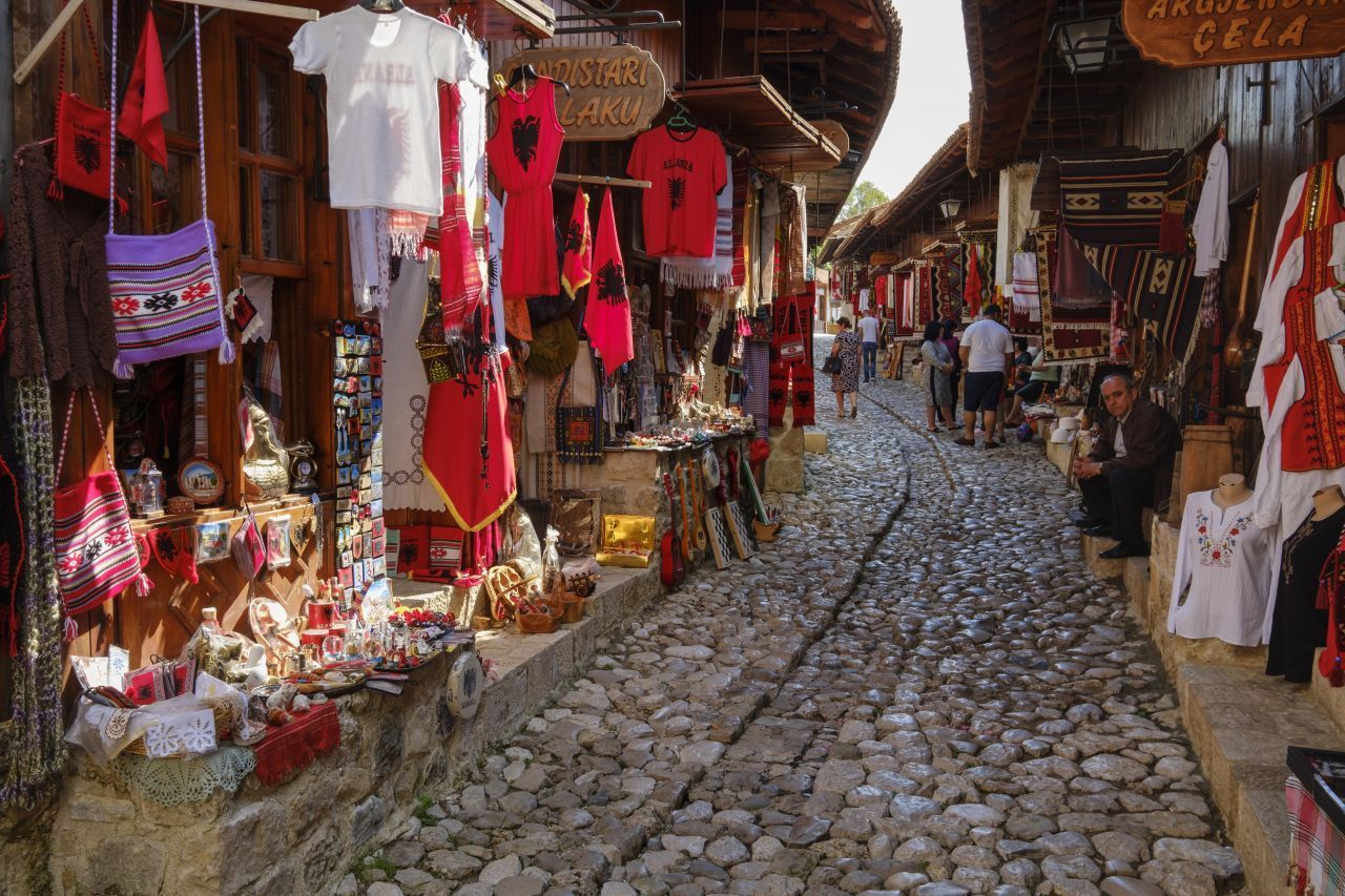 Wer Märkte und Souvenirs liebt, ist in Kruja goldrichtig. Der kleine Ort liegt in Mittel-Albanien am westlichen Steilhang des Mali i Krujës und punktet mit einer Basarstraße. Ihre Waren verkaufen die Händler in Gebäuden aus dem 19. Jahrhundert. Teppiche, Taschen, Silberschmuck, Kleidung, Geschirr, Schnickschnack - hier gibt's alles. 