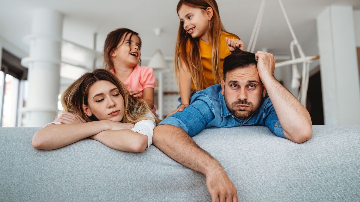 Tired mother and father feels annoyed exhausted while noisy little kids at home